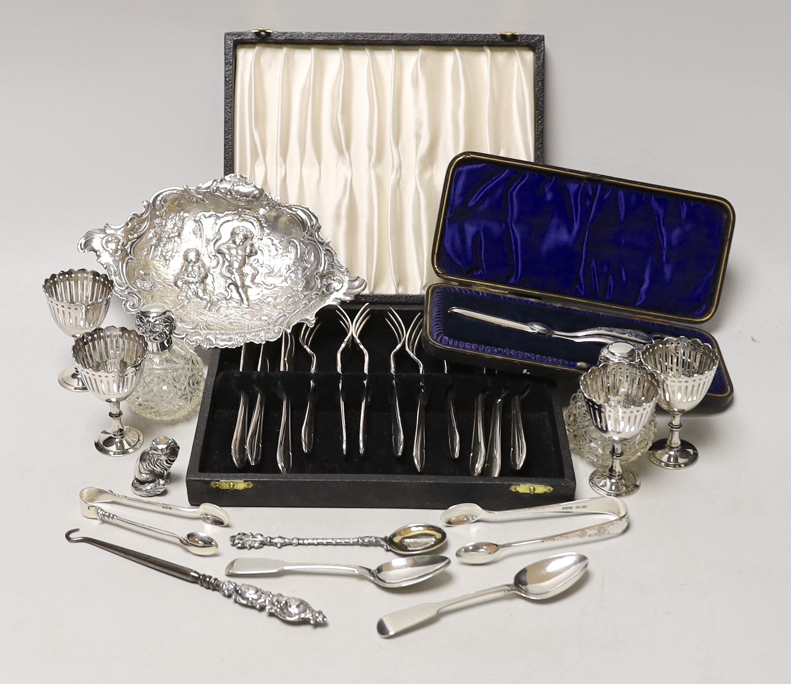 Sundry small silverwares including flatware, a pair of mounted glass scent bottles, a white metal German dish and minor plated items.